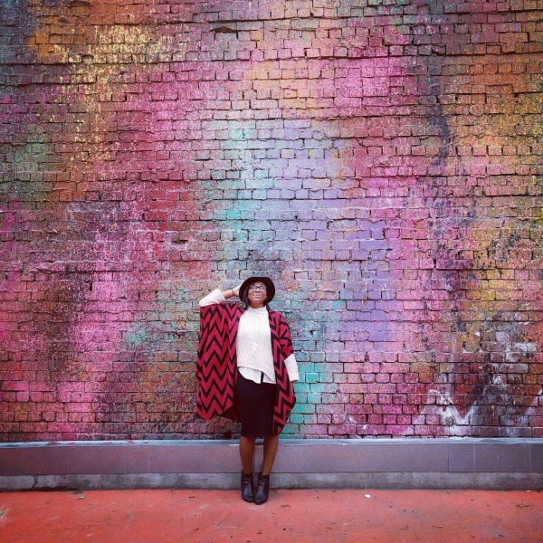 Ashley Langham poses in front of a colorful wall in Melbourne, Victoria
