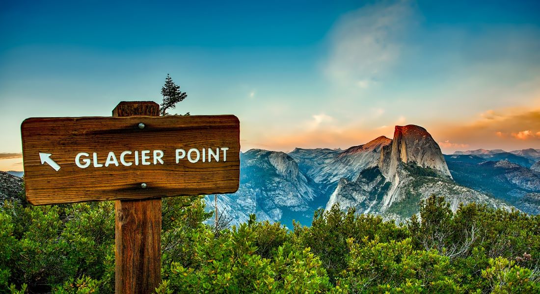 A wooden sign post points toward Glacier Point in Yosemite National Park
