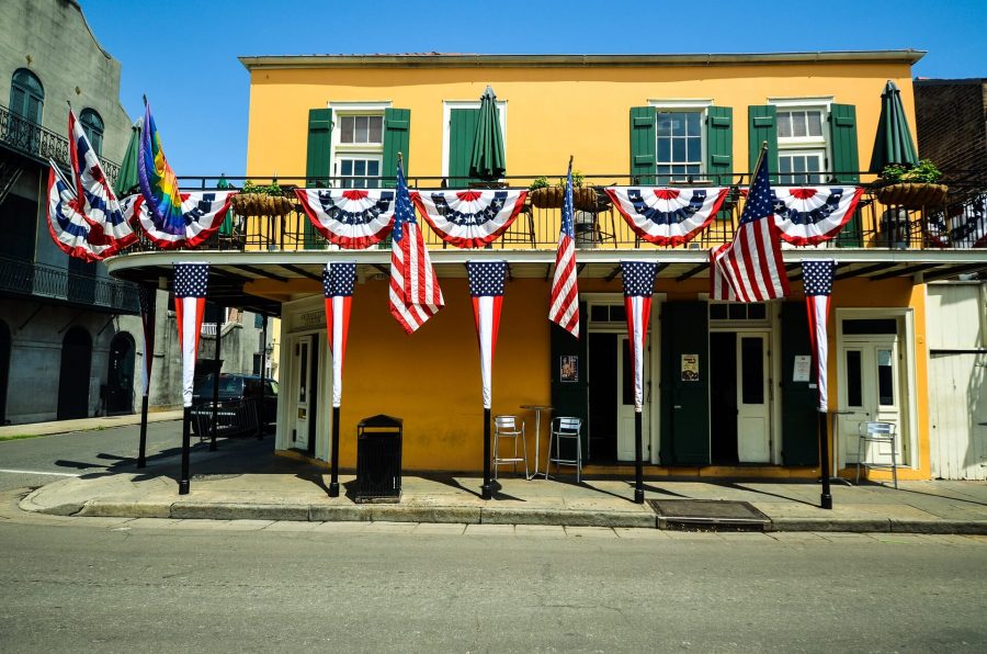 A yellow building draped with several USA flags in the French Quarter in New Orleans