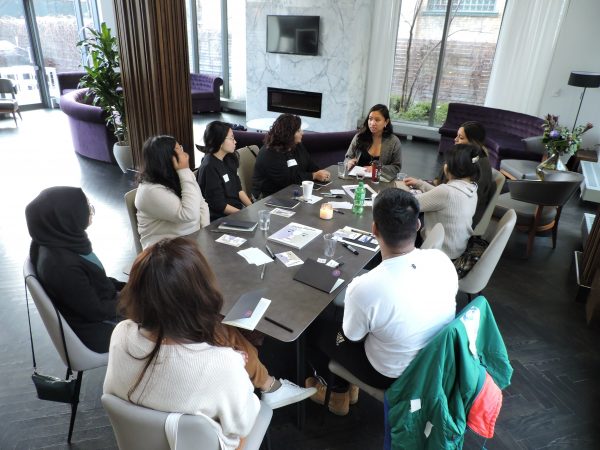 Conference room table with a group of people sat around.