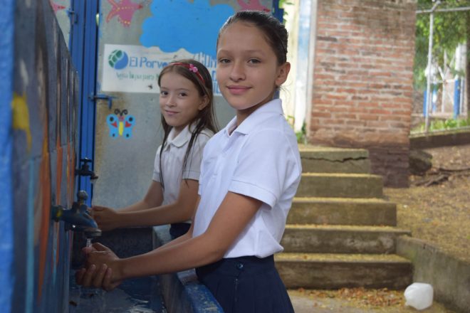 Two schoolgirls washing their hands in clean water. | Image courtesy of Just a Drop