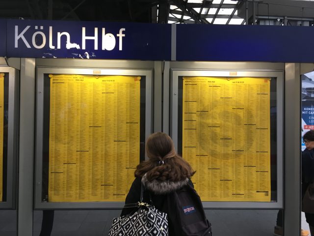 Amanda Walkins looking at the train schedule at Cologne train station